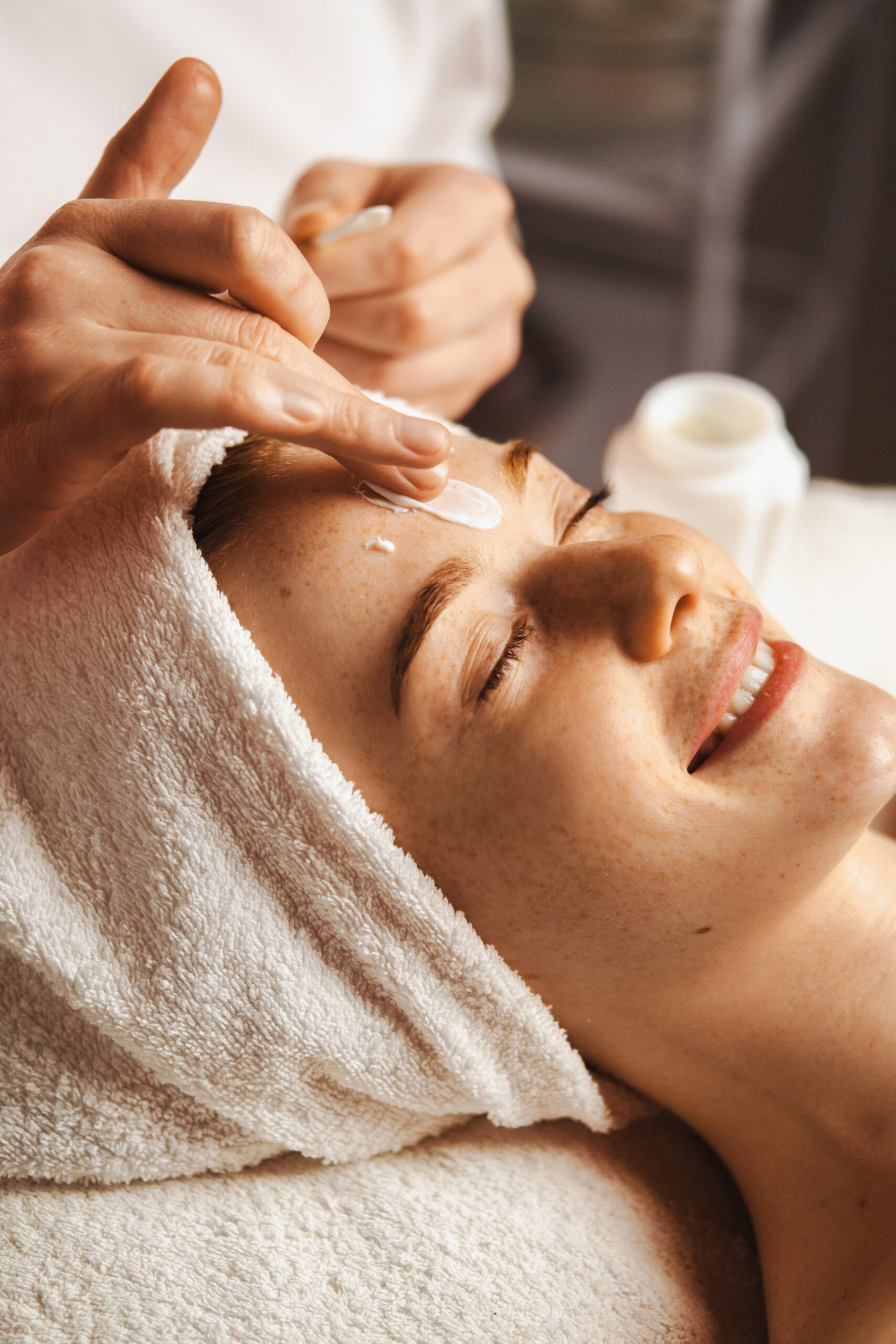 Close-up portrait of woman getting spa facial massage treatment with moisturising cream at beauty spa salon. Natural skin care cosmetic. Health care, beauty treatment. Facial beauty. Woman beauty face.