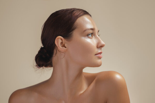 Side view portrait of a young woman with glowing, healthy skin in soft light. Ideal for beauty, skincare, and wellness campaigns. High-quality image for cosmetics or natural beauty promotions.